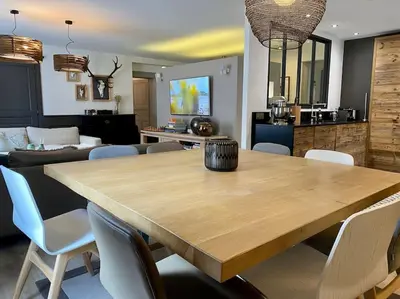 a dining room with a large wooden table and chairs at Appartement Mocca au coeur de Chamonix Mont-Blanc in Chamonix-Mont-Blanc