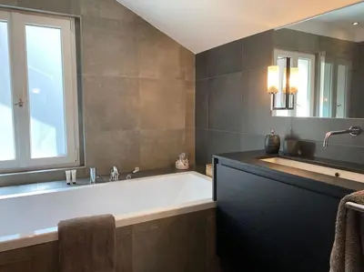 a large bathroom with a large tub and a window at Appartement Mocca au coeur de Chamonix Mont-Blanc in Chamonix-Mont-Blanc