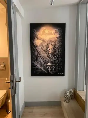 a picture on a wall with a painting on the wall at Appartement Mocca au coeur de Chamonix Mont-Blanc in Chamonix-Mont-Blanc