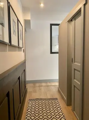 a hallway with a door and a rug on a floor at Appartement Mocca au coeur de Chamonix Mont-Blanc in Chamonix-Mont-Blanc