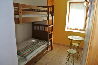a room with two bunk beds and a table at Le Refuge in Saint-Gervais-les-Bains