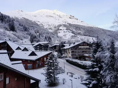 a town with snow covered buildings and a mountain at L'enclaves in Les Contamines-Montjoie
