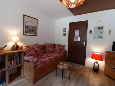 a living room with a couch and a table at T2 calme avec parking et wifi à Chamonix - FR-1-517-64 in Chamonix-Mont-Blanc