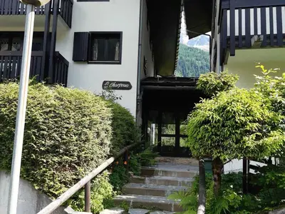 a building with stairs and bushes in front of it at T2 calme avec parking et wifi à Chamonix - FR-1-517-64 in Chamonix-Mont-Blanc