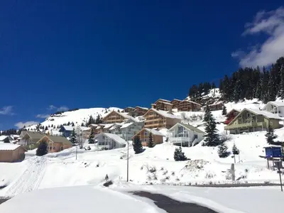 a snow covered mountain with houses on a hill at Chalet lumineux avec poêle à bois et WIFI gratuit - 6 à 8 personnes - Garage - FR-1-425-117 in Flaine