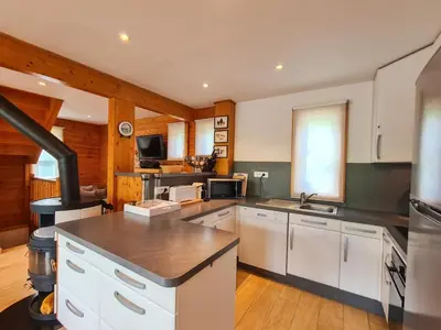 a large kitchen with white cabinets and a stove at Chalet lumineux avec poêle à bois et WIFI gratuit - 6 à 8 personnes - Garage - FR-1-425-117 in Flaine
