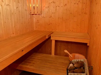 a sauna with two benches and a basket of rocks at Appartement spacieux avec sauna et grande terrasse, pour 10 pers. - FR-1-425-118 in Flaine
