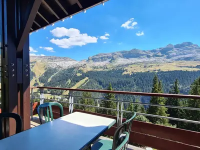 a table and chairs on a balcony with a view of mountains at Appartement spacieux, accès pistes, piscine, spa - FR-1-425-120 in Flaine