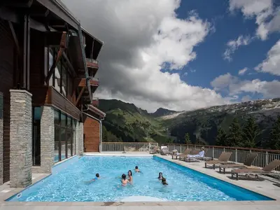 a group of people in a swimming pool with mountains at Appartement spacieux, accès pistes, piscine, spa - FR-1-425-120 in Flaine