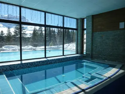 a large swimming pool in a room with windows at Appartement spacieux, accès pistes, piscine, spa - FR-1-425-120 in Flaine