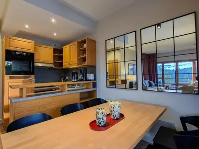 a kitchen with a wooden table and some chairs at Appartement spacieux, accès pistes, piscine, spa - FR-1-425-120 in Flaine