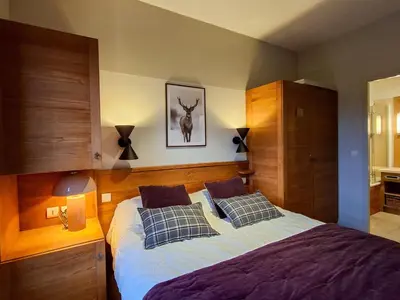 a bedroom with a bed with pillows and a deer picture on the wall at Appartement spacieux, accès pistes, piscine, spa - FR-1-425-120 in Flaine