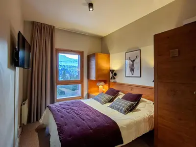 a bedroom with a bed with purple sheets and a window at Appartement spacieux, accès pistes, piscine, spa - FR-1-425-120 in Flaine