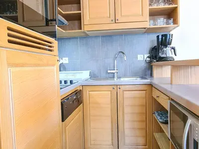 a kitchen with wooden cabinets and a sink at Appartement spacieux, accès pistes, piscine, spa - FR-1-425-120 in Flaine