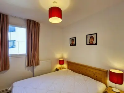 a bedroom with a bed with two lamps and a window at Appartement spacieux au centre, balcon, parking couvert - FR-1-425-124 in Flaine