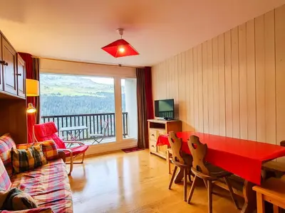 a living room with a red table and a balcony at Appartement 6 pers. confortable à Flaine avec balcon - FR-1-425-148 in Flaine