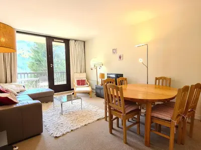 a living room with a wooden table and a dining room at Appartement lumineux au pied des pistes avec WIFI gratuit - FR-1-425-145 in Flaine