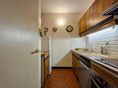 a kitchen with a refrigerator and a clock on the wall at Appartement lumineux au pied des pistes avec WIFI gratuit - FR-1-425-145 in Flaine