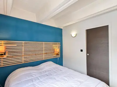 a bedroom with a blue accent wall and a bed at Appartement Confortable, Proche Pistes & Commerces, Balcon - FR-1-425-144 in Flaine