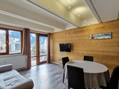 a room with a table and a tv on a wall at Appartement Confortable, Proche Pistes & Commerces, Balcon - FR-1-425-144 in Flaine