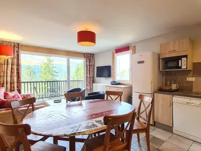 a kitchen and a dining room with a table and chairs at Appartement spacieux et lumineux · 8 personnes · Balcon · Flaine Centre - FR-1-425-134 in Flaine