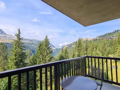 a balcony with a chair and a view of the mountains at Appartement spacieux et lumineux · 8 personnes · Balcon · Flaine Centre - FR-1-425-134 in Flaine