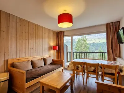 a living room with a couch and a table at Appartement lumineux avec balcon au centre station - FR-1-425-141 in Flaine