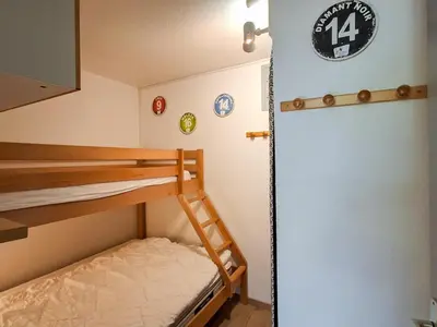 a room with two bunk beds and a wall with clocks at Studio rénové au centre de Flaine avec balcon pour 5 personnes - FR-1-425-154 in Flaine