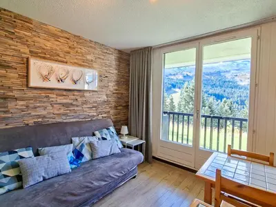a living room with a couch and a large window at Studio rénové au centre de Flaine avec balcon pour 5 personnes - FR-1-425-154 in Flaine