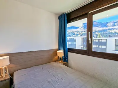 a bedroom with a bed and a window with a view at Appartement confortable au pied des pistes avec piscine et parking - FR-1-425-138 in Flaine