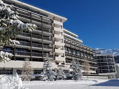 a building with snow covered trees in front of it at Appartement confortable au pied des pistes avec piscine et parking - FR-1-425-138 in Flaine