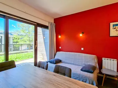 a bedroom with a bed and a red wall at Appartement confortable au pied des pistes avec piscine et parking - FR-1-425-138 in Flaine