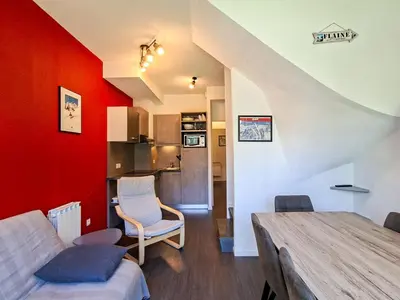 a living room with red walls and a table and chairs at Appartement confortable au pied des pistes avec piscine et parking - FR-1-425-138 in Flaine