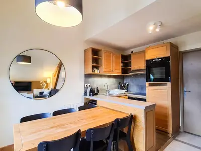 a kitchen with a wooden table and chairs and a mirror at Appartement confortable 3 pièces à Flaine - 6 pers - FR-1-425-140 in Flaine
