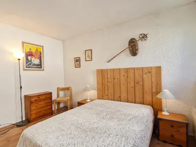 a bedroom with a bed and a clock on the wall at Appartement confortable au centre, balcon, 6 personnes - FR-1-425-142 in Flaine