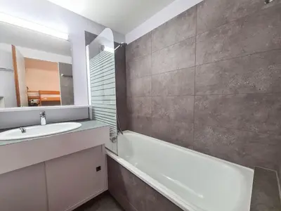 a bathroom with a sink and a tub and a mirror at Appartement confortable au centre, balcon, 6 personnes - FR-1-425-142 in Flaine