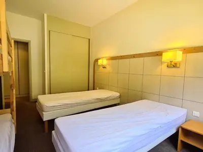 two beds in a room with two lamps on the wall at Appartement confortable proche des pistes avec casier à ski - FR-1-425-153 in Flaine