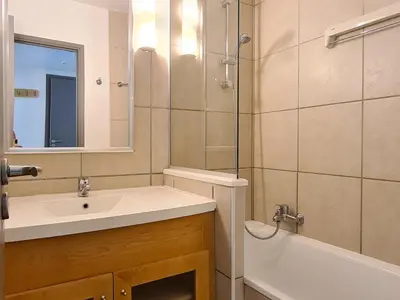 a bathroom with a sink and a mirror and a tub at Appartement Confortable 2 Pièces, Proche des Pistes, WIFI Gratuit - FR-1-425-165 in Flaine