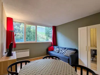 a living room with a blue couch and red curtains at Studio confortable proche des pistes, idéal pour 4 personnes - FR-1-425-182 in Flaine