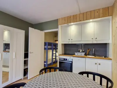 a kitchen with white cabinets and a table with chairs at Studio confortable proche des pistes, idéal pour 4 personnes - FR-1-425-182 in Flaine