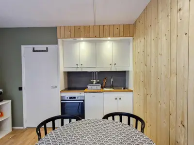 a kitchen with white cabinets and a table with chairs at Studio confortable proche des pistes, idéal pour 4 personnes - FR-1-425-182 in Flaine