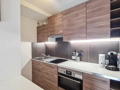 a kitchen with wooden cabinets and a sink at Studio neuf pour 4 pers. au centre de Flaine avec balcon - FR-1-425-170 in Flaine