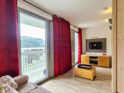 a living room with a large window and a television at Studio neuf pour 4 pers. au centre de Flaine avec balcon - FR-1-425-170 in Flaine