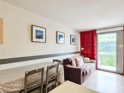 a bedroom with a bed and a couch and a window at Studio neuf pour 4 pers. au centre de Flaine avec balcon - FR-1-425-170 in Flaine