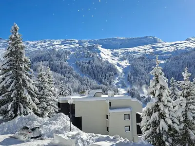 a snow covered mountain with a building and trees at Studio confortable à Flaine, balcon et proximité pistes - FR-1-425-180 in Flaine