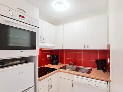 a small kitchen with white cabinets and red tiles at Appartement Confortable 4 Pers. Flaine Centre, Balcon Sud - FR-1-425-161 in Flaine