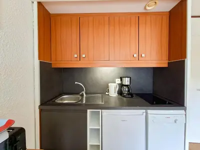 a small kitchen with wooden cabinets and a sink at Studio rénové 4 pers · Centre Flaine · Balcon Sud - FR-1-425-176 in Flaine