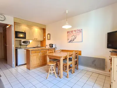 a kitchen with a wooden table and a dining room at Studio rénové avec balcon proche des pistes, casier à ski - FR-1-425-156 in Flaine