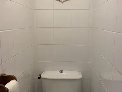 a white tiled bathroom with a toilet in it at Studio rénové avec balcon proche des pistes, casier à ski - FR-1-425-156 in Flaine