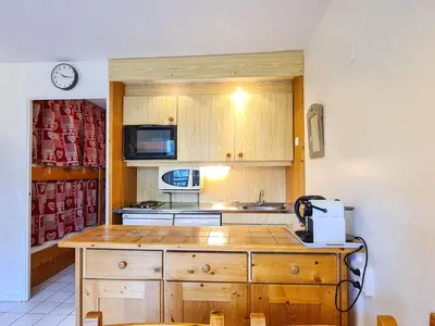 a kitchen with wooden cabinets and a counter top at Studio rénové avec balcon proche des pistes, casier à ski - FR-1-425-156 in Flaine